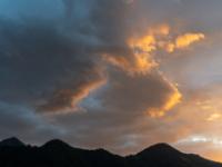 Von der Abendsonne orangegelb leuchtender Wolkenhaufen über den Aschauer Bergen